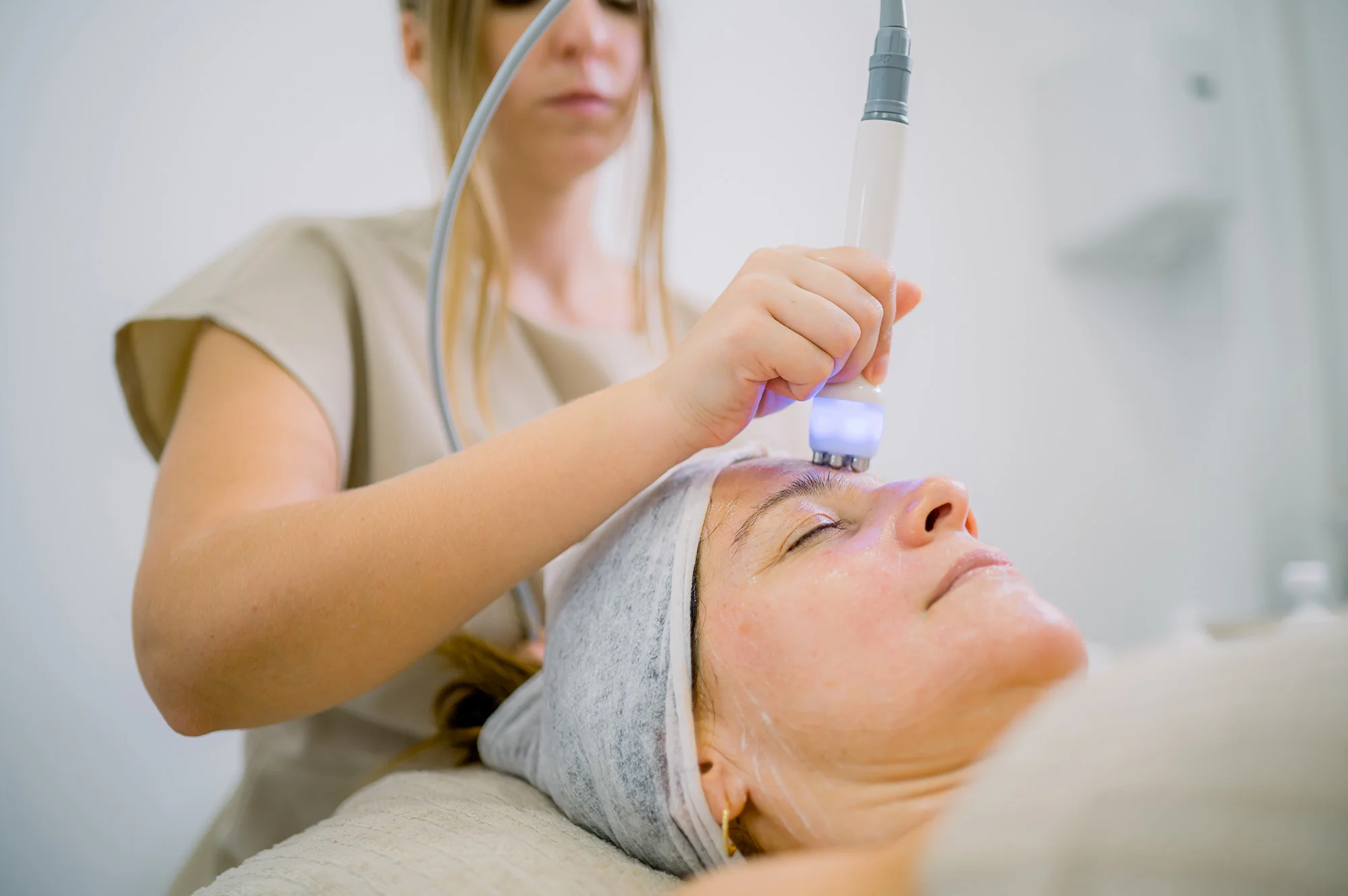 Female patient receiving facial redness treatment targeting facial vessels.